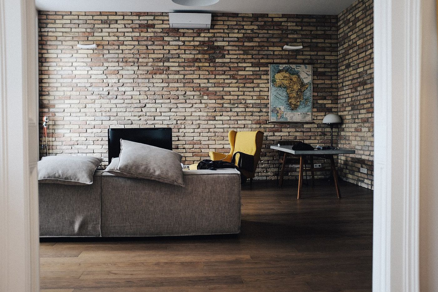 Living room with an exposed brick wall and grey sofa